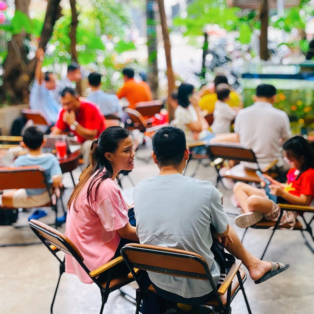 Khách ngồi trò chuyện trong khu sân vườn của quán cà phê dùng cà phê True Cafe