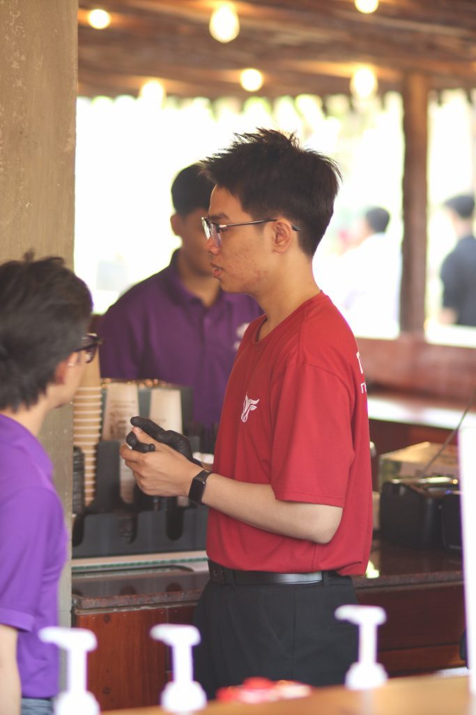 Nhân sự True Cafe áo đỏ chuẩn bị ly cà phê cho khách tại quầy pha chế sự kiện