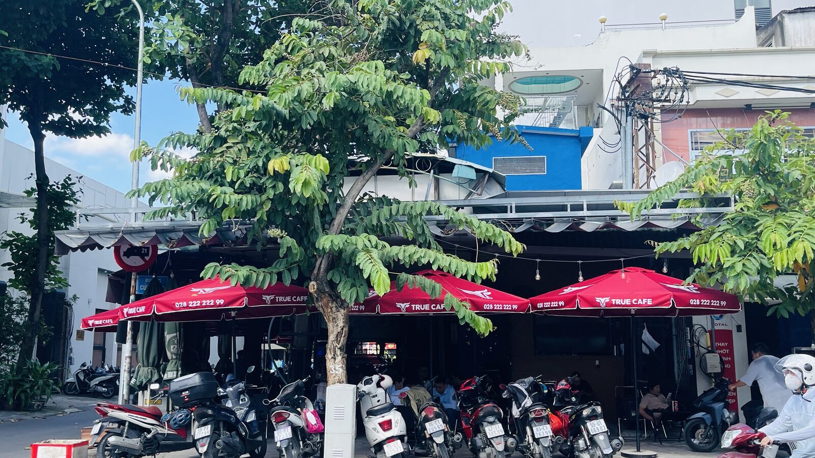 Mặt tiền quán cà phê mới mở với dàn dù đỏ True Cafe trước cửa