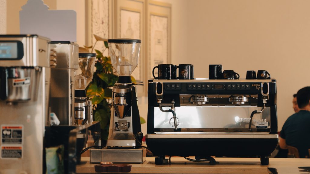 Kỹ thuật viên chỉnh mức xay trên máy xay cà phê tại quán